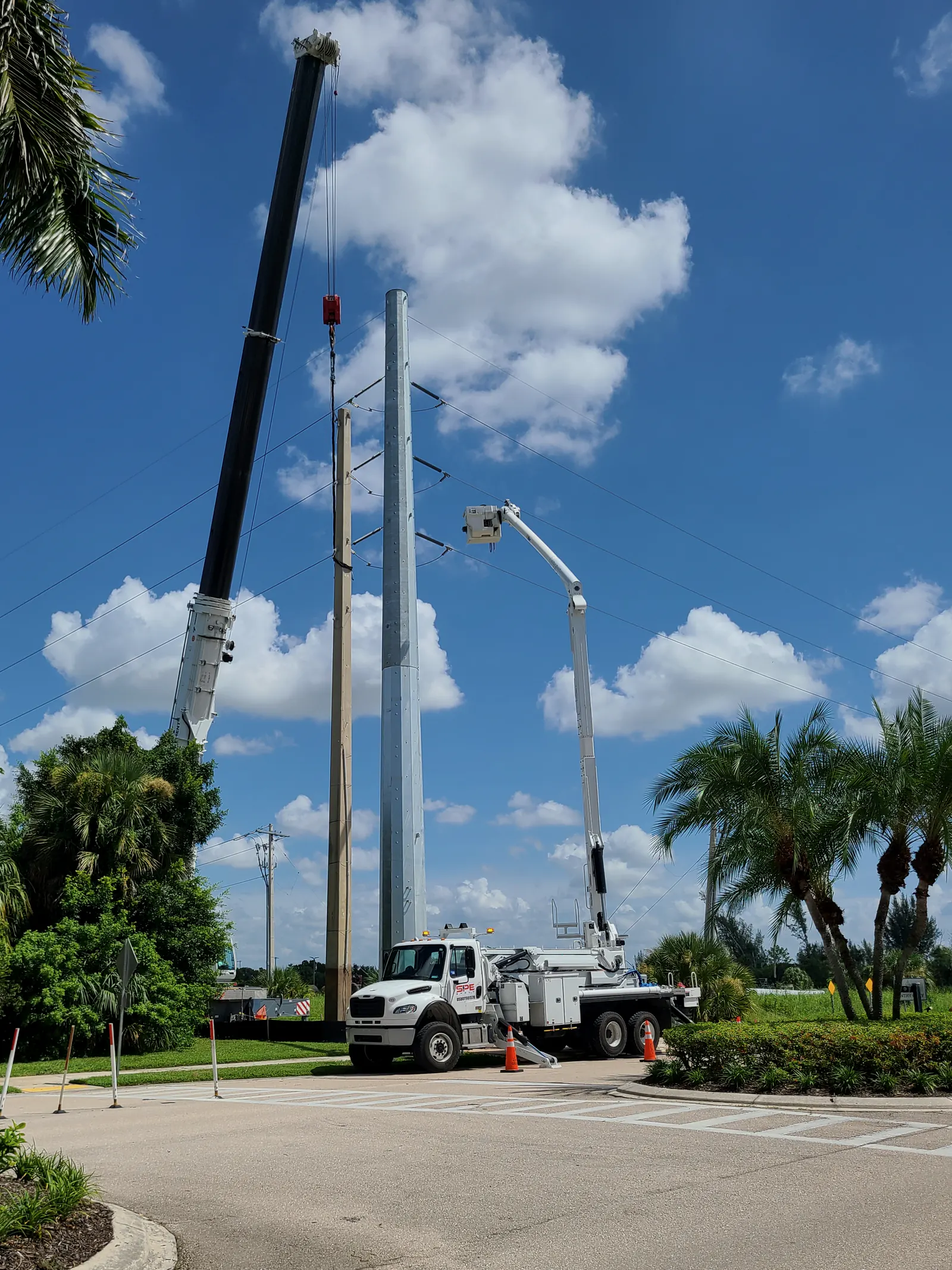 SPE crane and bucket truck crews setting a steel transmission pole