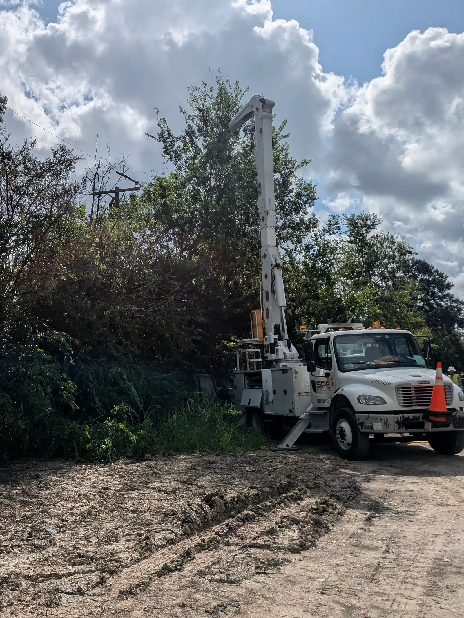 SPE bucket truck working a cleared right-of-way during storm restoration